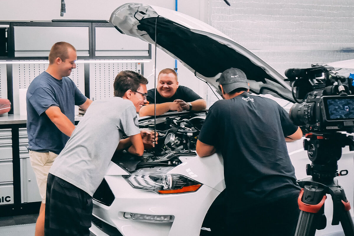 white s550 mustang working under hood